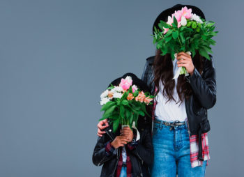 Mãe e filha segurando buquês de flores